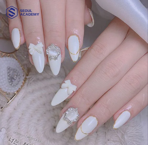 Một trong những mẫu nail tết màu trắng charm nơ mà các nàng nên thử vào dịp tết
