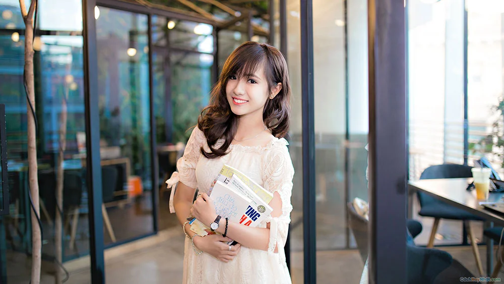 Gái xinh Việt Nam cầm sách tạo dáng trong quán cafe