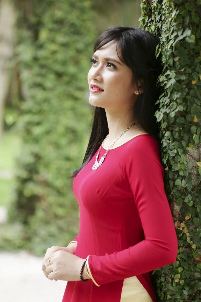 Hình ảnh gái xinh Việt Nam duyên dáng trong tà áo dài đỏ bên tường cây leo