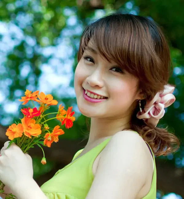 Chân dung gái xinh Việt Nam tươi cười cầm hoa ngoài trời